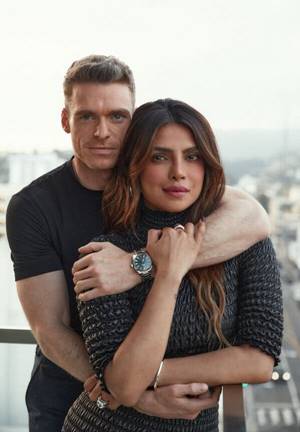 Madden wraps his arms around Chopra Jonas from behind and she grasps his forearms as they stand on a balcony in Los Angeles. 